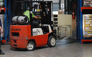 forklift driver in red forklift in warehouse